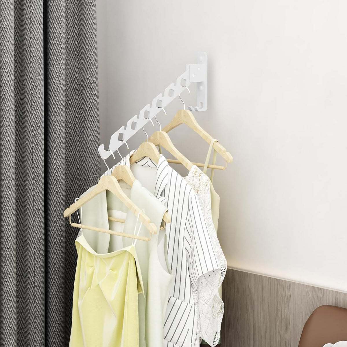 Drying rack in a corner holding tops on hangers