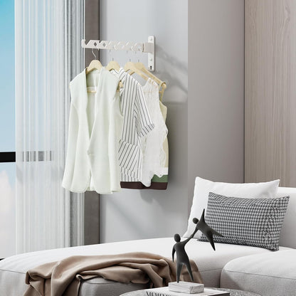 Drying rack on a living room wall holding shirts on hangers